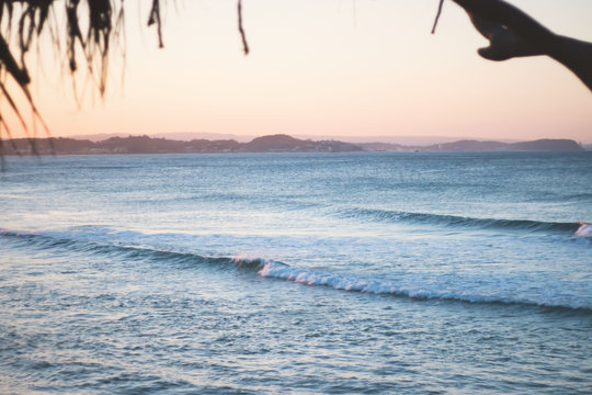 surfer on the beach pink sky 