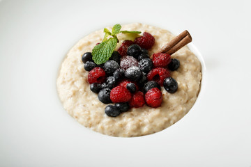 Close up of oatmeal with berries on white plate