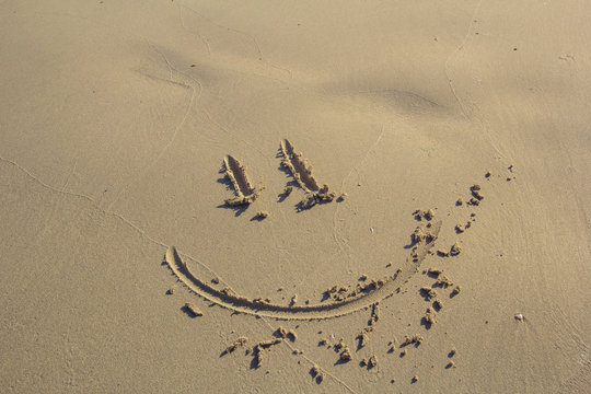 smile drawn in the sand