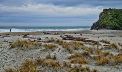 Solitary man walking along on the beach  after a storm
