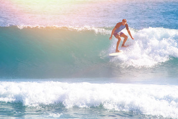 man in the ocean on a surfboard caught the wave. picking up speed