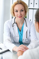 Doctor woman looking at  patient while speaking to her and reassuring. Medicine, healthcare and help concept 