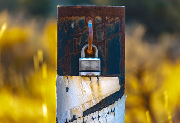 Padlock on a metal pole to lock road access