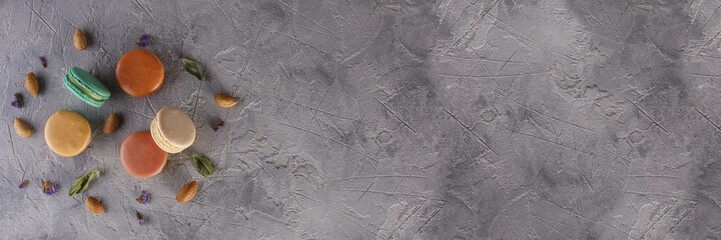 Macaroons, and almond nuts on a textural background. Flat lay. Nutrition concept. Banner with space for your text.