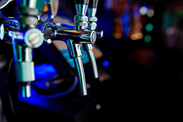 The beer taps in a pub. nobody. Selective focus. Alcohol concept. Vintage style. Beer craft. Bar table. Steel taps. Shiny taps.