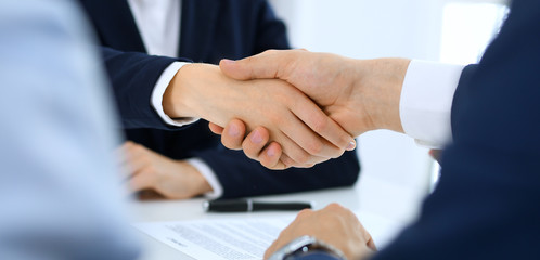 Obraz premium Group of business people or lawyers shaking hands finishing up a meeting , close-up. Success at negotiation and handshake concepts