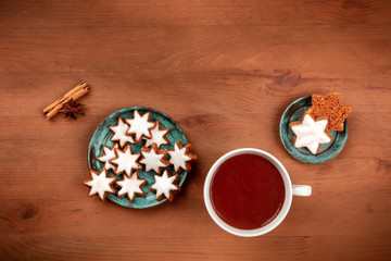 Christmas Zimtsterne, cinnamon star cookies, shot from the top on a rustic wooden background with hot chocolate and a place for text