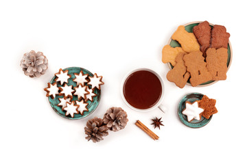 A photo of Zimtsterne and Spekulatius, traditional Christmas cookies, shot from the top on a white background with hot chocolate, spices, pine cones and a place for text