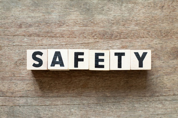 Naklejka premium Letter block in word safety on wood background