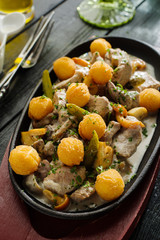 Slices of pork and rabbit liver with mushrooms in sour cream sauce garnished with potato balls.