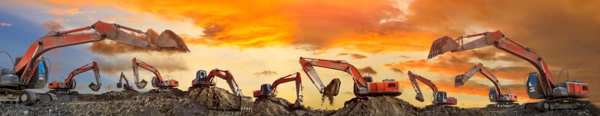 Many excavators work on construction site at sunset,panoramic view