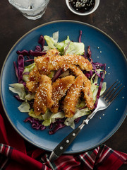 Salad with warm glazing chicken, sprinkled with sesame seeds. Chinese cuisine. Asian culture