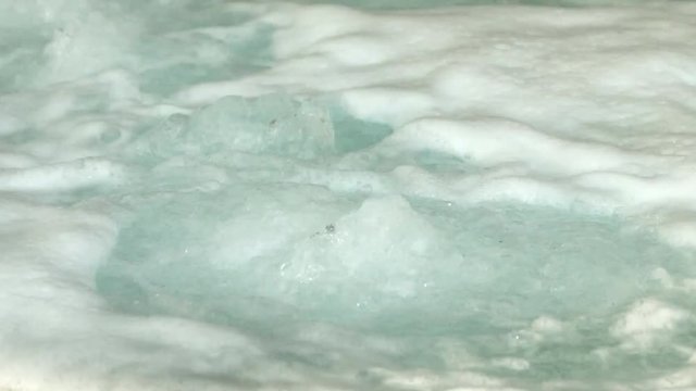 Modern round jacuzzi bathtub full of bubbling water with no people in it