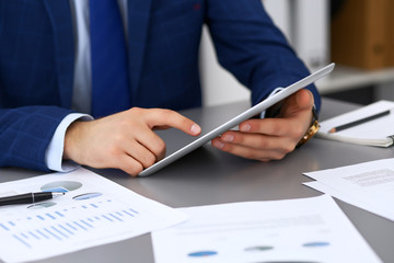 Businessman using touchpad at meeting, closeup of hands