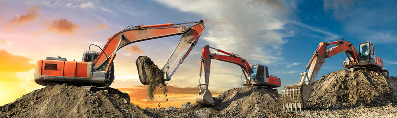 Three excavators work on construction site at sunset,panoramic view - obrazy, fototapety, plakaty