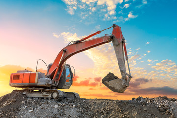 Excavator work on construction site at sunset