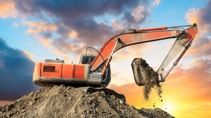 Excavator work on construction site at sunset