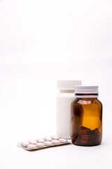 White and brown bottle of medicine Bottles, tablets, pills in blister pack, medications drugs selective focus copy space