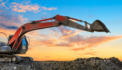 Excavator work on construction site at sunset