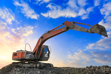 Excavator work on construction site at sunset