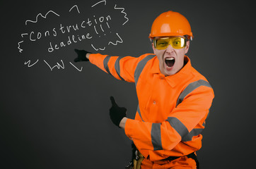 Angry and annoyed builder worker or architect is showing on a copy space behind him and is shouting about bad done work. A foreman discontented by a work.