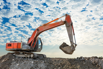 Excavator working at building site on sunny day