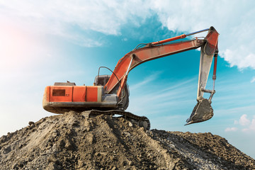 Excavator working at building site on sunny day