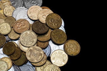 Ukrainian coins isolated on black background. Close-up view. Coins are located at the left side of frame. A conceptual image.