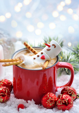 Red mug with cappuccino with melted marshmallow snowman