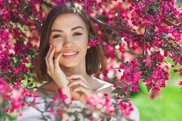 Obraz na płótnie Canvas Close up portrait of young beautiful woman with perfect smooth skin. Attractive lady in flowers. Facial portrait of beautiful female.