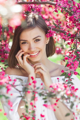 Obraz na płótnie Canvas Close up portrait of young beautiful woman with perfect smooth skin. Attractive lady in flowers. Facial portrait of beautiful female.