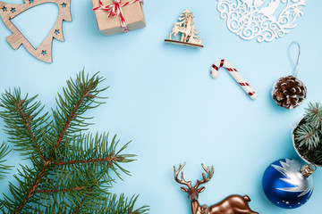 Top view of empty space on blue table with christmas decoration. Top view of empty sapce with little gift present, new year decoration, branches of trees. Copy space