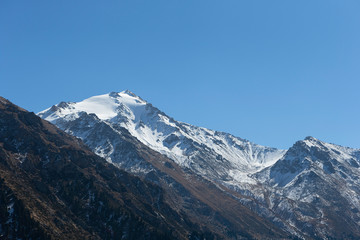 Fototapeta na wymiar Snow-capped peaks in the mountains of Almaty