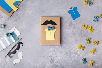Making greeting card for Fathers Day. Shirt with butterfly from pasta. Card from paper. moustache. Childrens art project. Step-by-step photo instruction. Child makes card layout. Top view