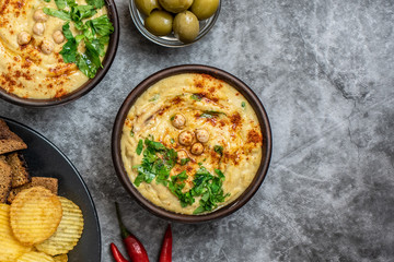 Classic hummus in bowls on a grey background. With copy space. Top view