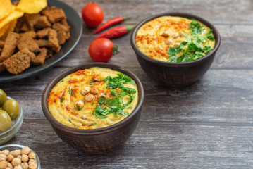 Classic hummus in bowls on wooden table