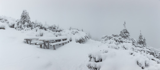 Panorama of heavy snow on top of the mountain. Cold winter day with heavy fog and snow