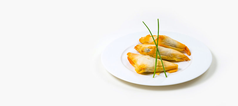 Samosa on a white plate on a white background
