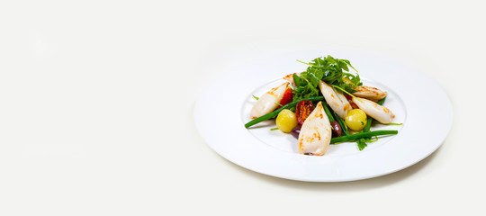 Seafood Salad with tomato and calamari on a white plate on a white background isolated