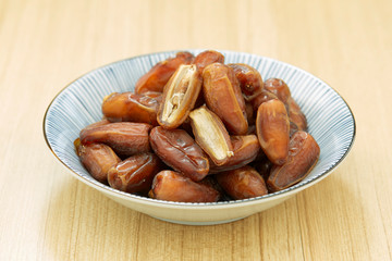 Sweet dried dates fruit in a bowl and on the table