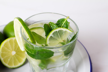 drink, water, mojito with lime and mint in a glass close-up.