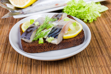 Open sandwich with salted Atlantic mackerel closeup at selective focus