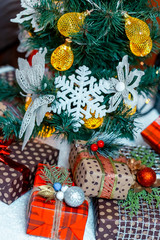 Christmas gifts in the snow under the tree. The concept of home holiday, surprises and present