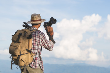 photographer holding his camera. Travelers hold a DSLR camera on the mountain.