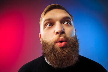 Wow. Attractive male half-length front portrait on colored studio backgroud. Young emotional...
