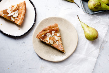 A slice of tart with poached pears and almond frangipane
