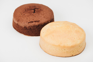 close-up view of delicious baked white and brown cakes isolated on white