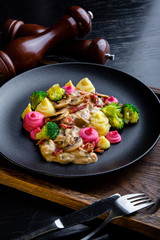 delicious Beef Strogans Restaurant Dish in restaurant background. Healthy exclusive food on big black platter closeup