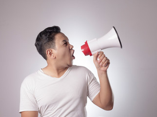 Young Man Shouting with Megaphone, Angry Expression