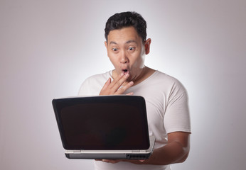 Young Man Looking at Laptop, Surprised Expression